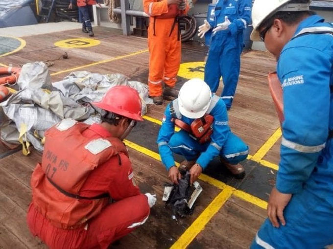 Picture 1 of Fragments, luggage, and phones float at the place where Indonesian planes fall