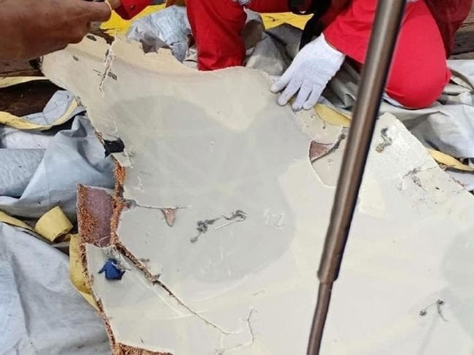 Picture 3 of Fragments, luggage, and phones float at the place where Indonesian planes fall