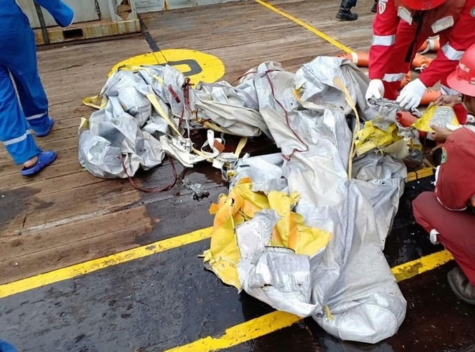Picture 5 of Fragments, luggage, and phones float at the place where Indonesian planes fall