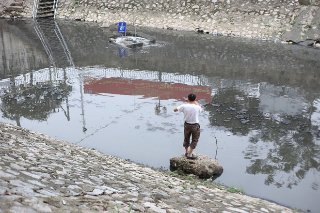 Picture 10 of People 'leisurely' sit fishing on the banks of To Lich River