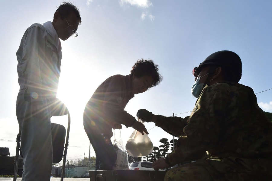 Picture 6 of The Japanese lined up to receive rice balls after the earthquake disaster