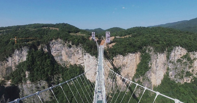 China has completed the construction of a 300-meter-high glass bridge connecting the two mouths
