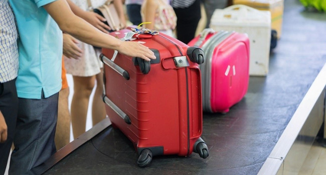 How does the suitcase always appear first on the conveyor belt?