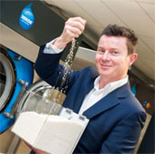 Manufacturing washing machines using polymer particles to clean clothes