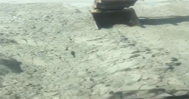 The ground heaves like a wave of water under a digging bucket
