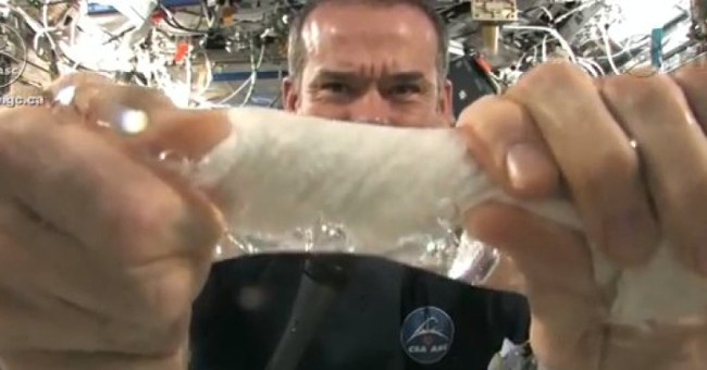 Video: A miserable astronaut squeezes a wet towel on a space station