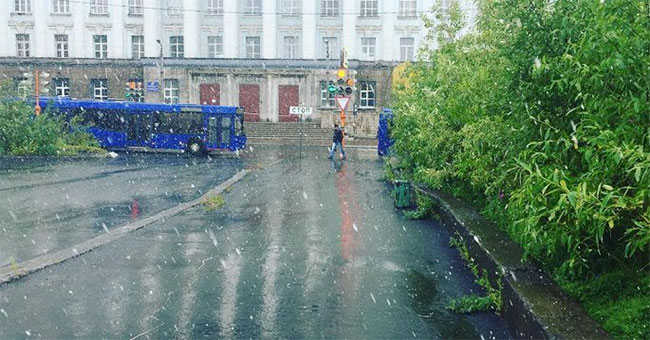 White snow falls in the middle of summer in the Russian city