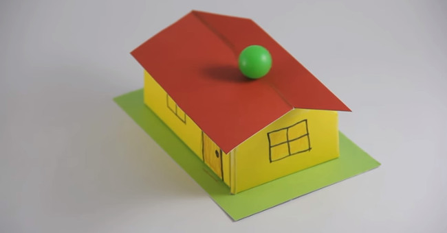 Why does this ball not fall off the roof?