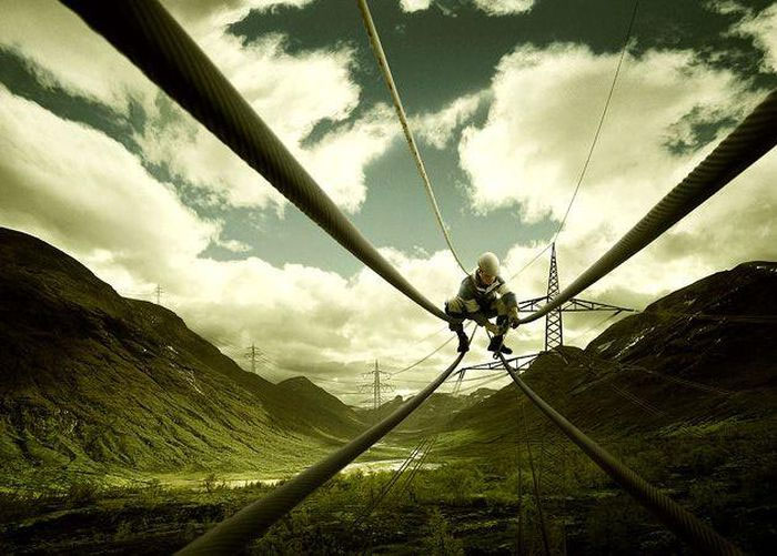 Picture 1 of Heart-stopping scene at the scene of a man sitting on a helicopter, holding a metal rod near a high-voltage wire