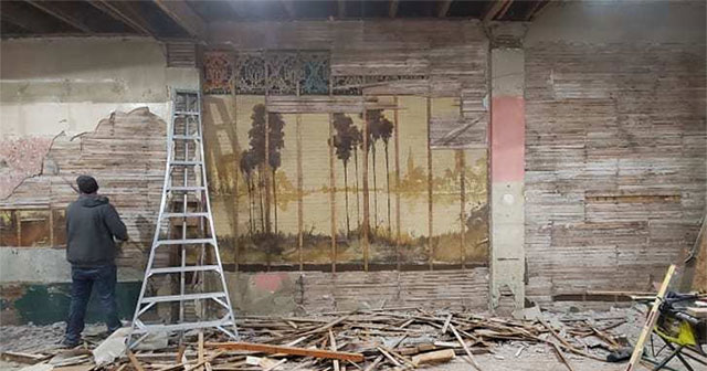 A hundred-year-old 'terrible' painting is hidden in the wall of an old house