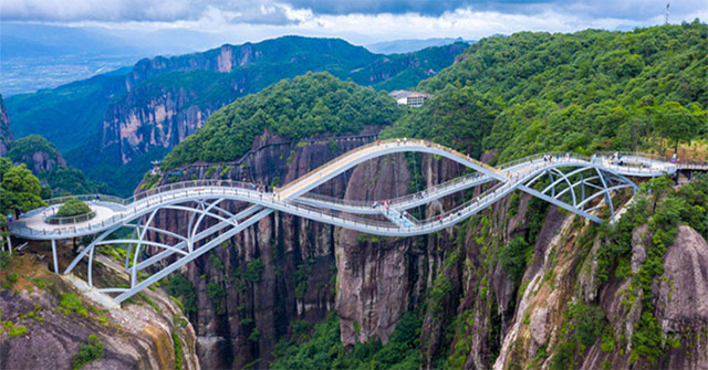 A unique glass bridge winding through the clouds in China