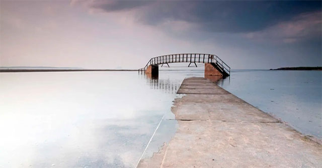 The bridge is suspended in the middle of the water with a path leading directly down to the 'aquarium'