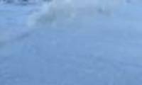 Beach covered with white foam like snow mats