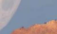 The illusion of the Moon falling behind the volcano peak